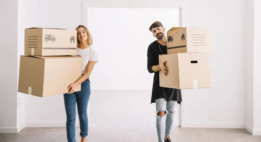 two poeple carrying house removal boxes