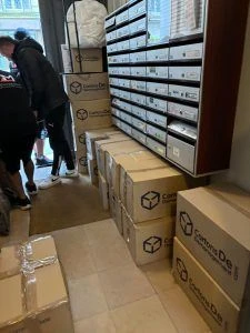 People standing in front of boxes in a room, during a move or storage.